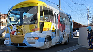 Tokyo, Japan - 18 December 2014: Typical children school bus, decorated with cute animal drawings, picking up kid