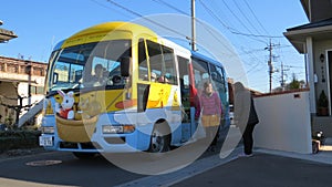 Tokyo, Japan - 18 December 2014: Typical children school bus, decorated with cute animal drawings, picking up kid