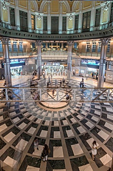 Motion blurred people conmuting and stainless steel columns at Tokyo Station Marunouchi building