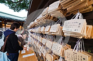 TOKYO, JAPAN - NOVEMBER 23, 2013 : People writting Ema Plaques at a Meiji Jingu Shrine.