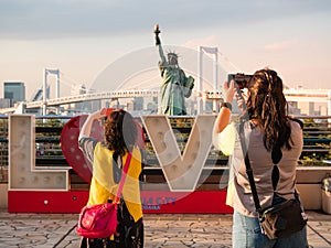 Tourist taking picture of Statue of Liberty in Odaiba area, Tokyo, Japan