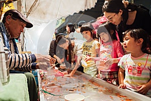 Tokyo, Japan - September 5, 2020 : japanese old man is putting goldfishes in the plastic bag and give to the girl while the other