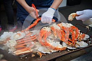 Tokyo, Japan Street in Tsukiji outer market in Ginza with closeup retail sample display of cooked red crab lobster legs white meat