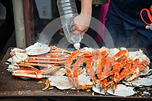 Tokyo, Japan Street in Tsukiji outer market in Ginza with closeup retail sample display of cooked red crab lobster legs white meat