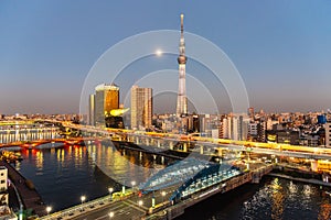 Tokyo Skytree and Sumida river in sunset sky with full moon
