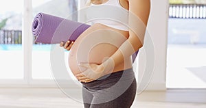 They told me yoga was good for the baby. Cropped shot of an unrecognizable young pregnant woman carrying a yoga mat.