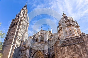 Toledo Cathedral, Gothic church facade with great portals, statues, reliefs, bell tower, Spain.