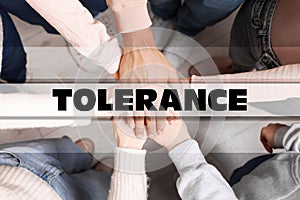 Tolerance concept. Group of multiracial people joining hands together, top view