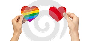 Tolerance and discrimination concept. Hands with LGBT rainbow heart and red heart. Gay and lesbian rights