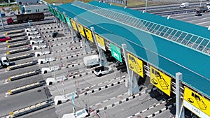 Toll roads on the broad highway. Through the point passes a large number of trucks and cars. Close up view