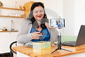 A tolstaya woman leads a video blog in a room, in the office.