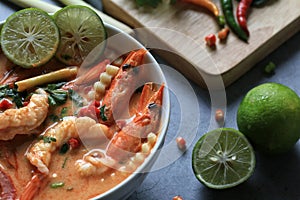 Tom Yam Kung, Spicy shrimp soup is popular Thai hot and sour soup recipe served in white bowl on cement background