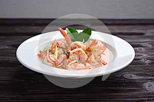 Tom Yum Goong Clear Spicy Sour Soup on wooden table top view, Thai local food