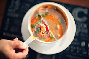 Tom Yum Goong thai hot spicy soup on wooden table,Thai popular food menu