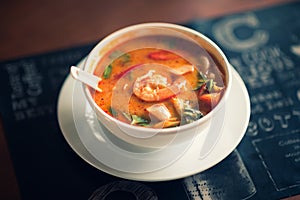 Tom Yum Goong thai hot spicy soup on wooden table,Thai popular food menu