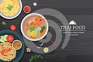 Tom yum kung in the bowl on black wood table top view. Thailand set food background photo