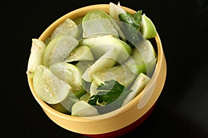 Tomatillo slices in bowl with cilantro