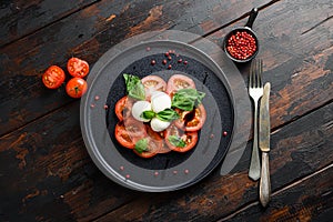 Tomato, basil, mozzarella Caprese salad with balsamic vinegar and olive oil. old wooden planks background over head top view