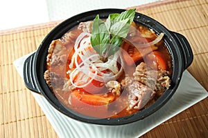 Tomato and Beef Brisket Casserole noodles served in borth isolated on table top view of Claypot