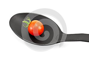 Tomato on a black spoon