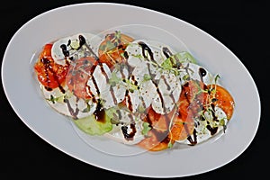 Tomato buffalo mozzarella salad in a white plate