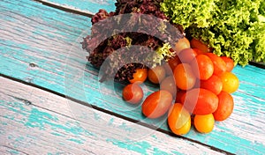 Tomato cherry with green and red leaf lettuce on top wooden table. Fresh ingredient for making healthy salad and sandwiches