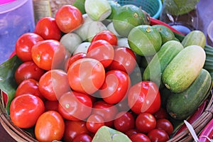 Tomato, cucumber, lemon and eggplant in a bamboo basket. Ingredients for making papaya salad.