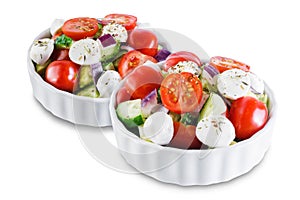 Tomato cucumber red onion mozzarella salad on a white isolated background