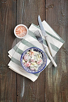 Tomato and cucumber salad with sour cream in a small bowl