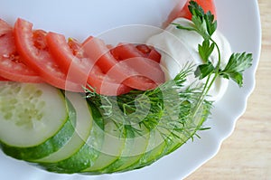 Tomato and cucumber on white plate