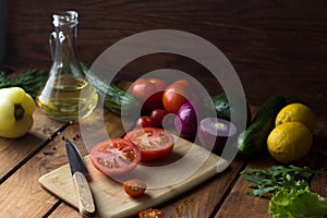 the tomato cut in half is sprinkled with large pieces of salt on a cutting board