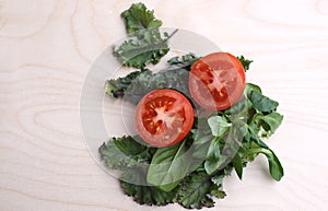 Tomato cut into two parts and spinach green fresh on white background side view