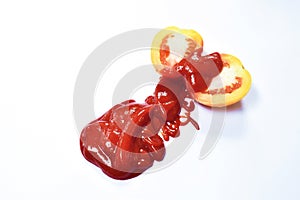 Tomato with drop of water half cut and ketchup flowing on white background