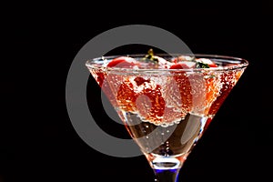 Tomato floats in water with bubbles in glass glass glass on white background.