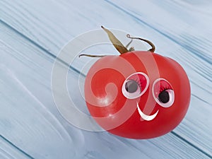 Tomato funny organic person eyes cartoon on blue wooden positive emotion