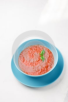 Tomato gazpacho soup in blue bowl.