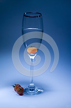Tomato in the glass in light blue background