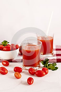 Tomato juice in a glass and fresh tomatoes. on a white background. food
