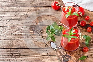 Tomato juice with mint in glass and fresh tomatoes on a wooden table. Healthy organic food concept Copy space