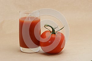 Tomato juice and tomato against beige background