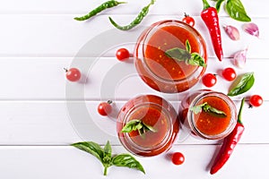 Tomato ketchup sauce with cherry tomatoes and red hot chili peppers, garlic and herbs in a glass jar