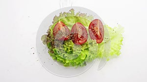 Tomato on lettuce sprinkle with basil slow motion