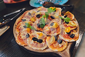 Tomato and mozzarella mini pizzas on board.