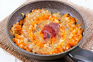 Tomato onion carrot and tomato paste in a pan