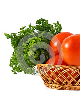 Tomato and parsley in wooden branch basket isolated on white background