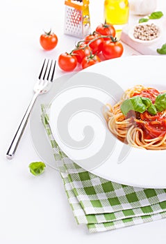 Tomato pasta spaghetti with fresh tomatoes, basil, italian herbs and olive oil in a white bowl
