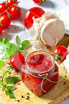 Tomato paste, home preservation. Tomato sauce made from ripe tomatoes on a wooden tabletop.