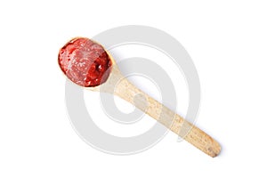 Tomato paste on a wooden spoon isolated on white