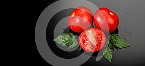 Tomato. Ripe natural tomatoes close-up. Organic tomato with leaves on black background