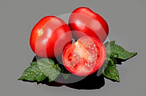Tomato. Ripe natural tomatoes close-up. Organic tomato with leaves on gray background